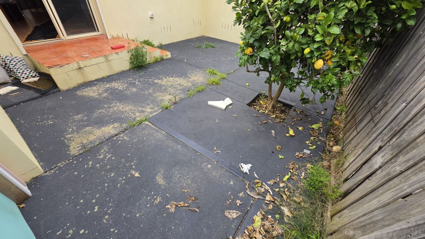 Tired asphalt courtyard before crazy paving renovation