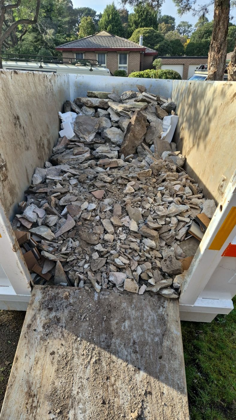 Demolished stone and concrete loaded into a tipper for licensed disposal