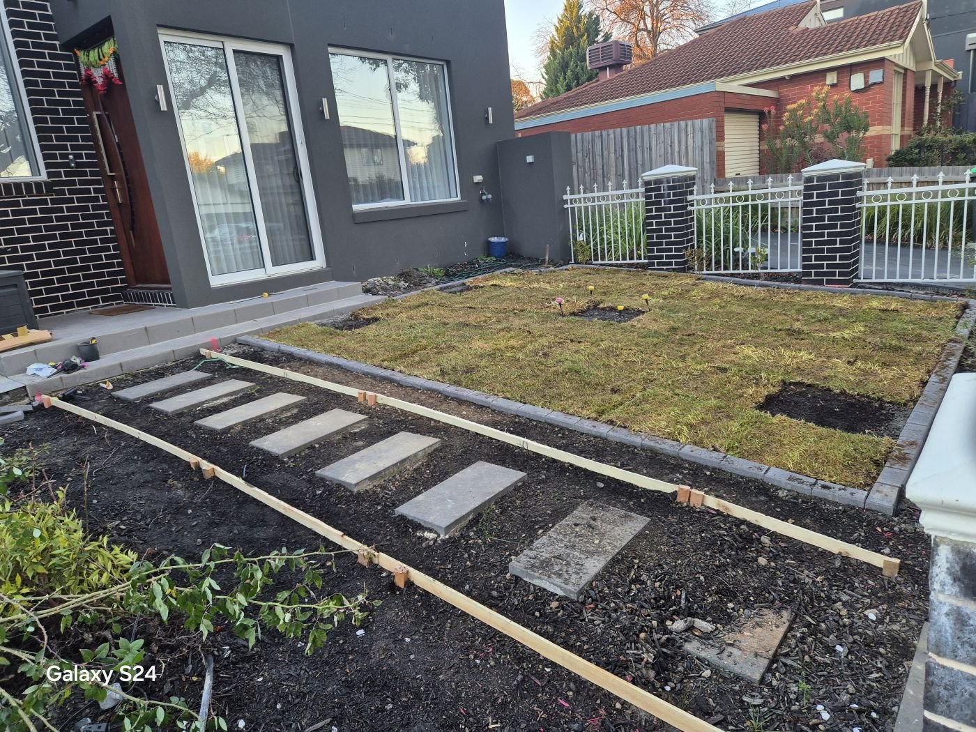 Stepping stones being set and turf laid in a new front yard