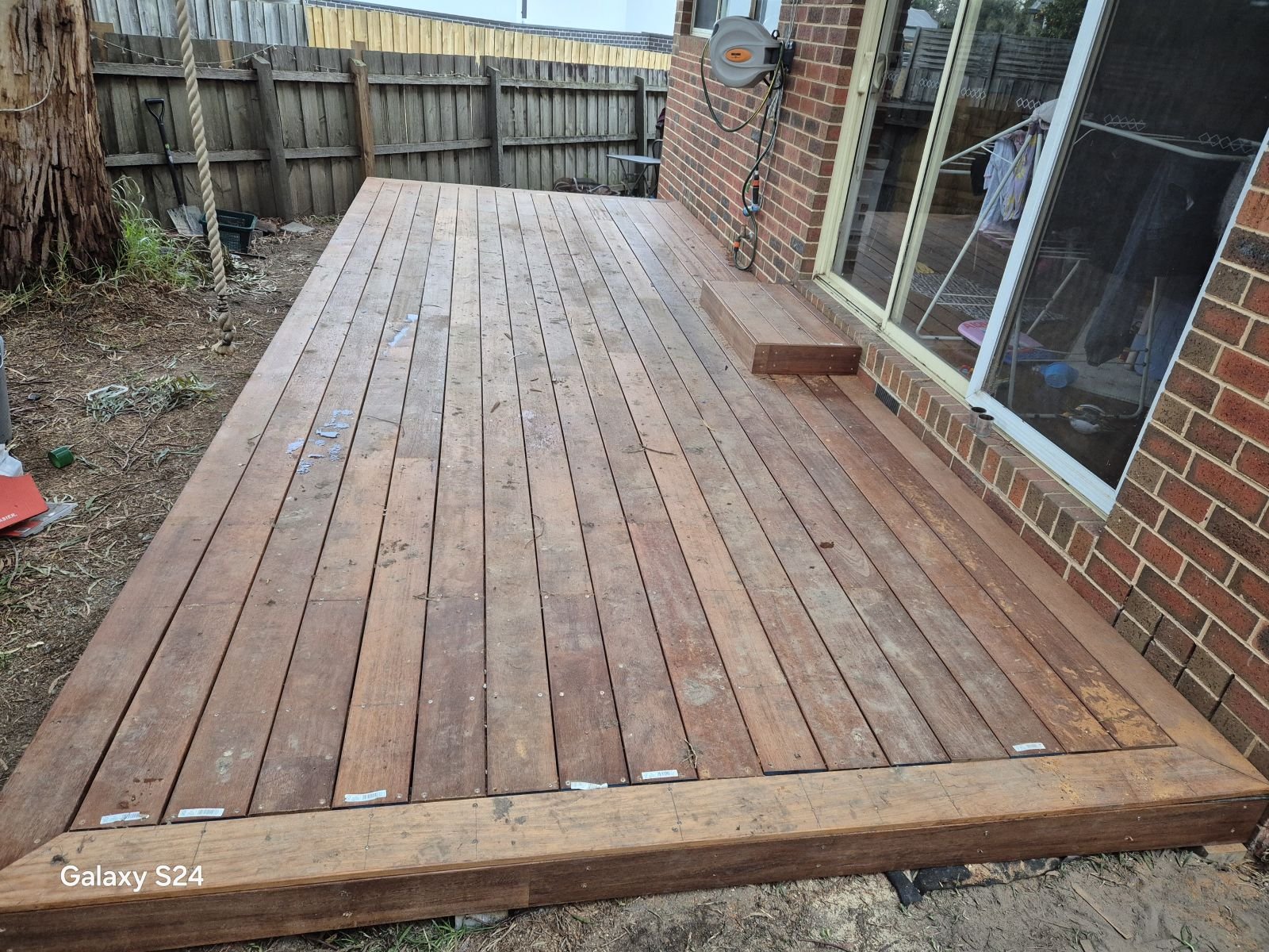 Finished merbau deck with step along a brick home