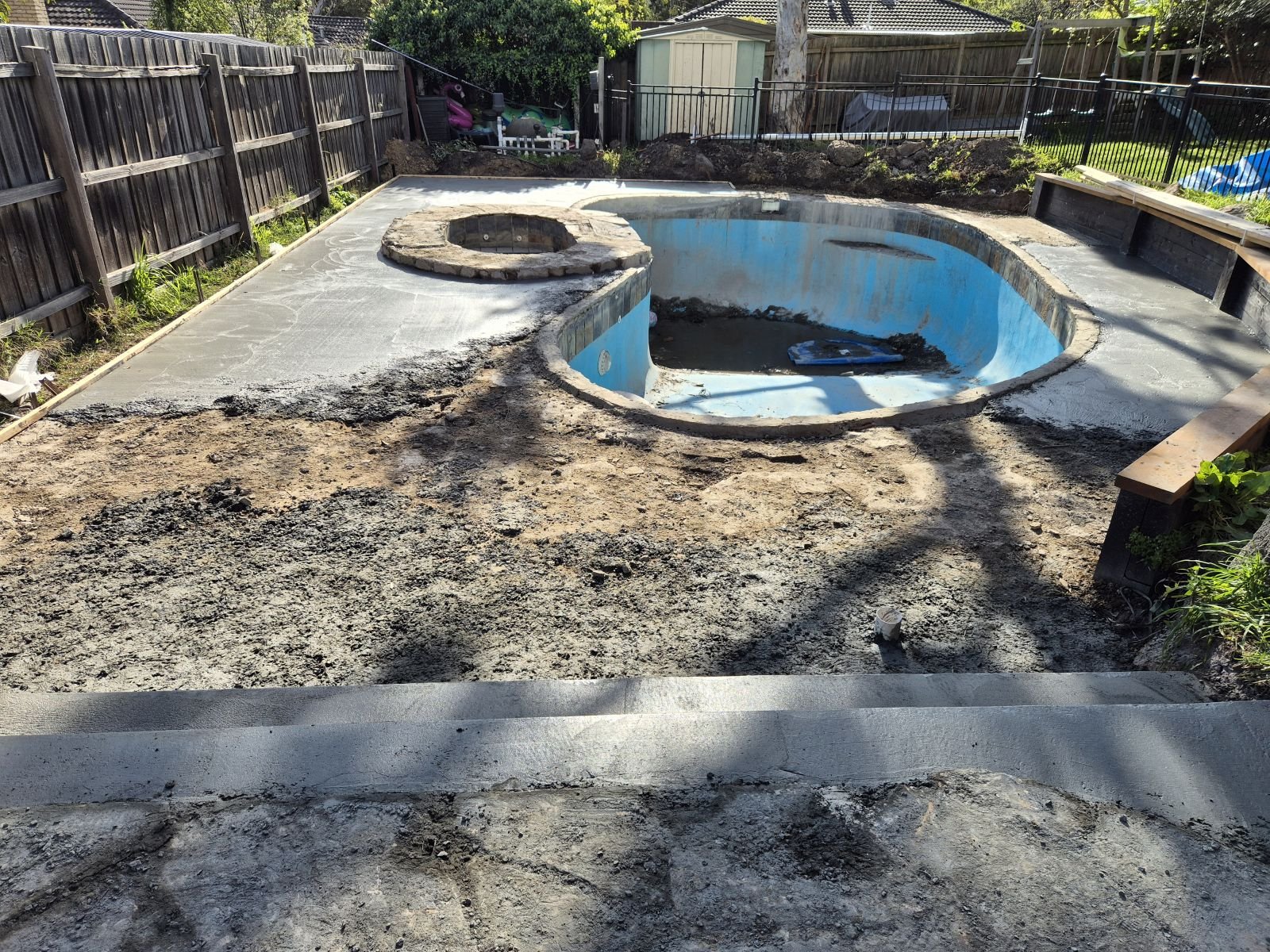 New base and formed edges prepared around a kidney-shaped pool