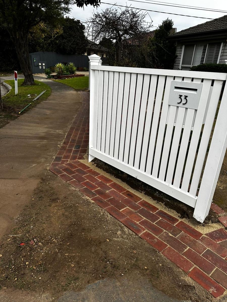 White picket fence with brick edging